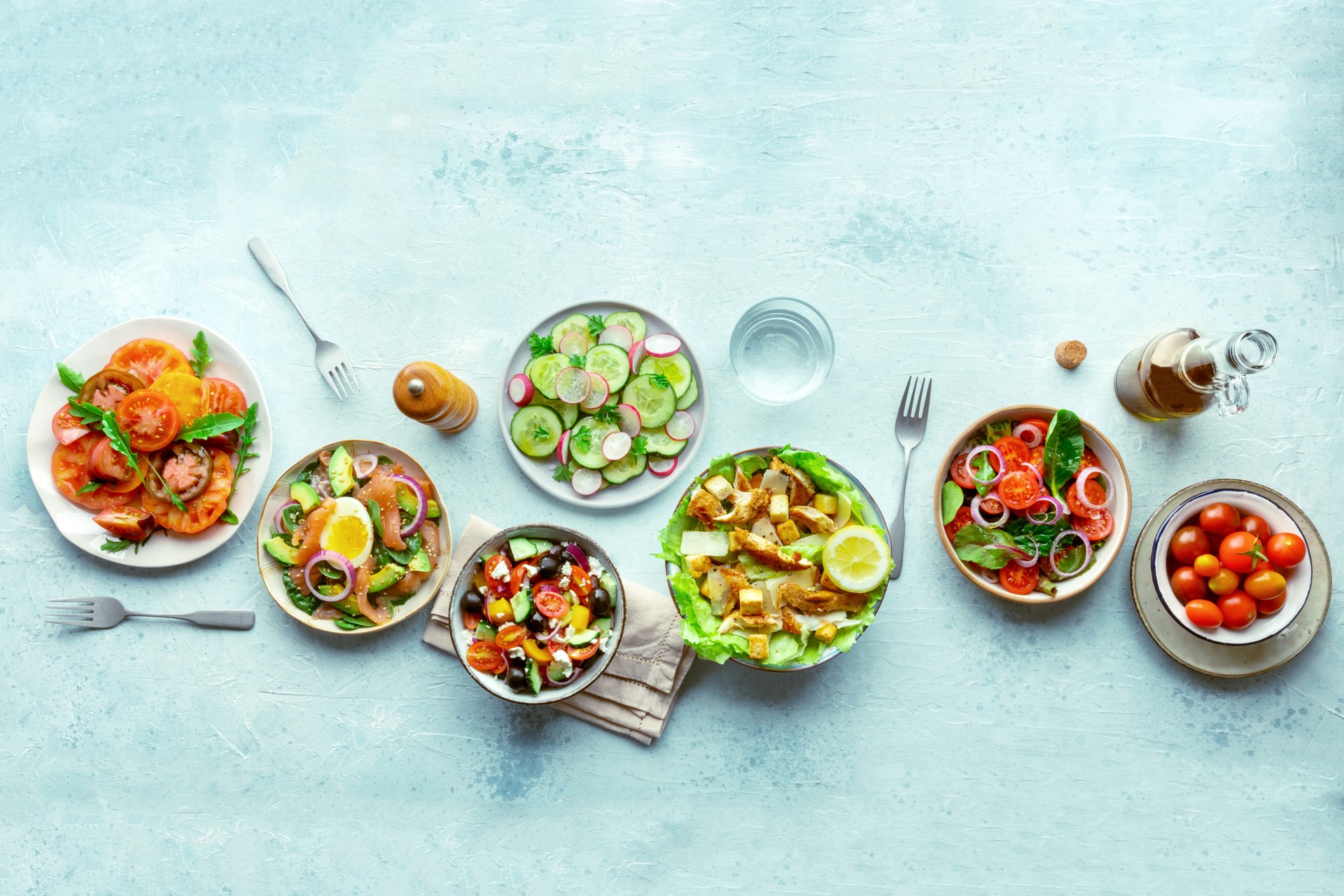 Fresh salads, overhead flat lay shot of an assortment. Variety of plates